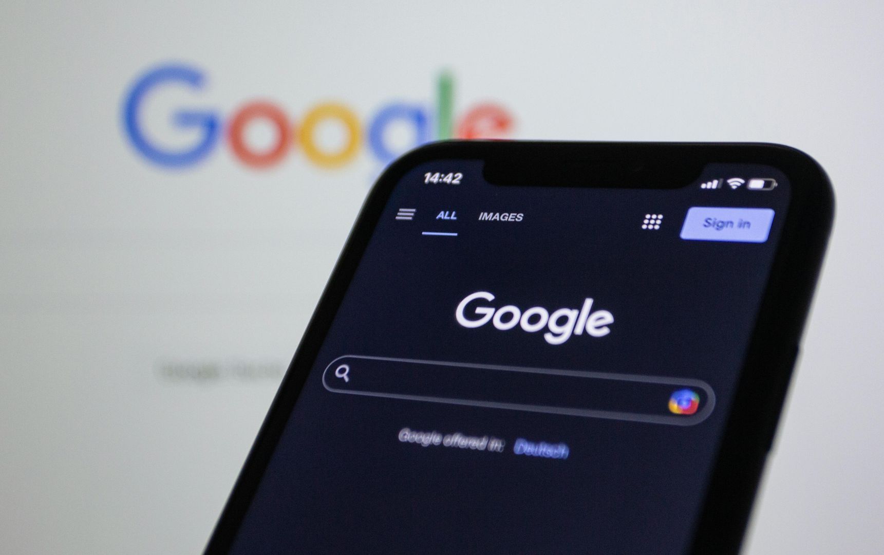 Google search page shown on a smartphone with the Google logo in the background