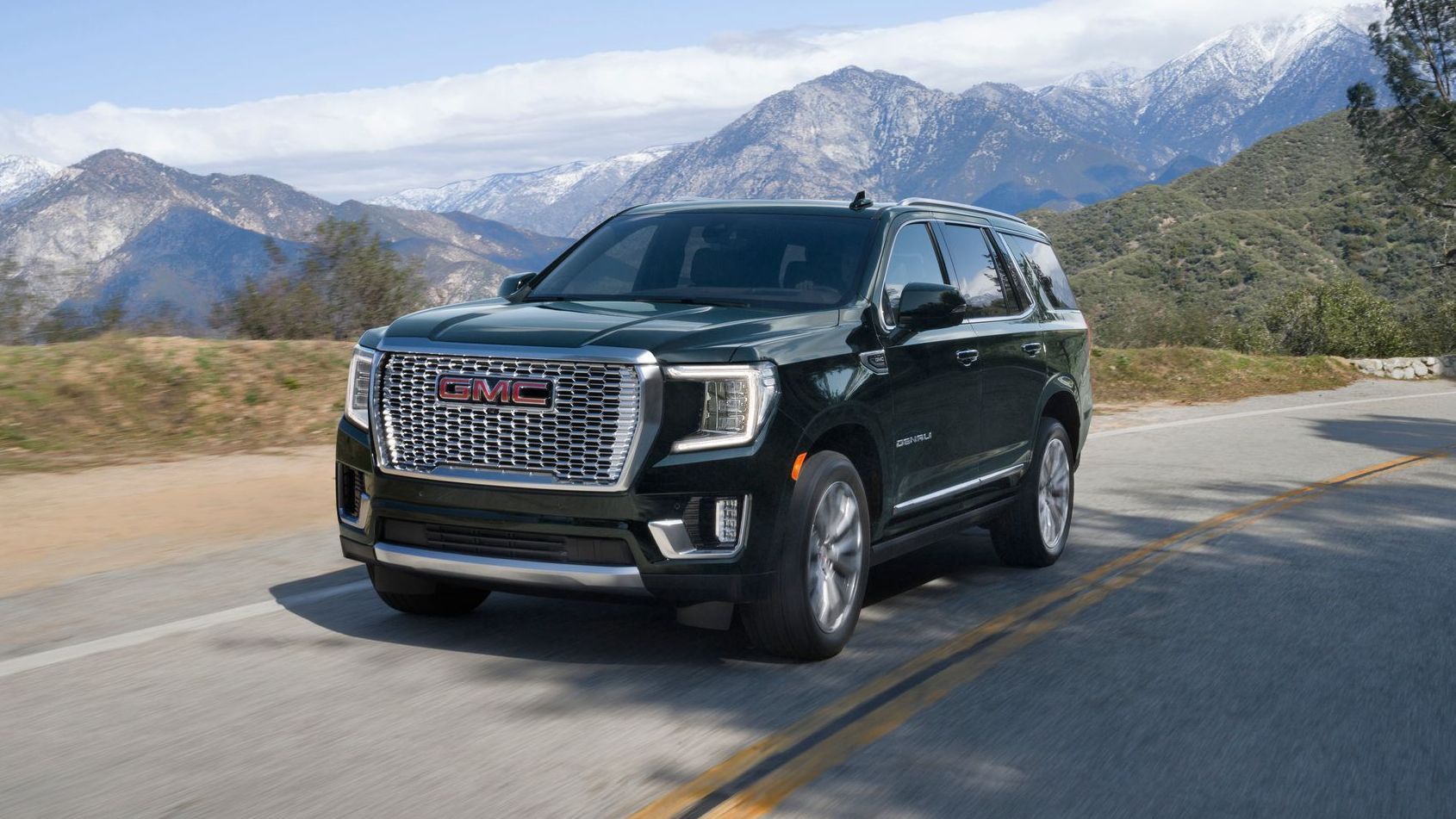A gmc yukon is driving down a mountain road.