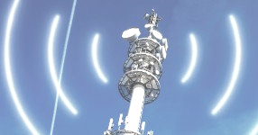 A telecommunications tower against a blue sky, featuring glowing, concentric signal waves radiating outward.