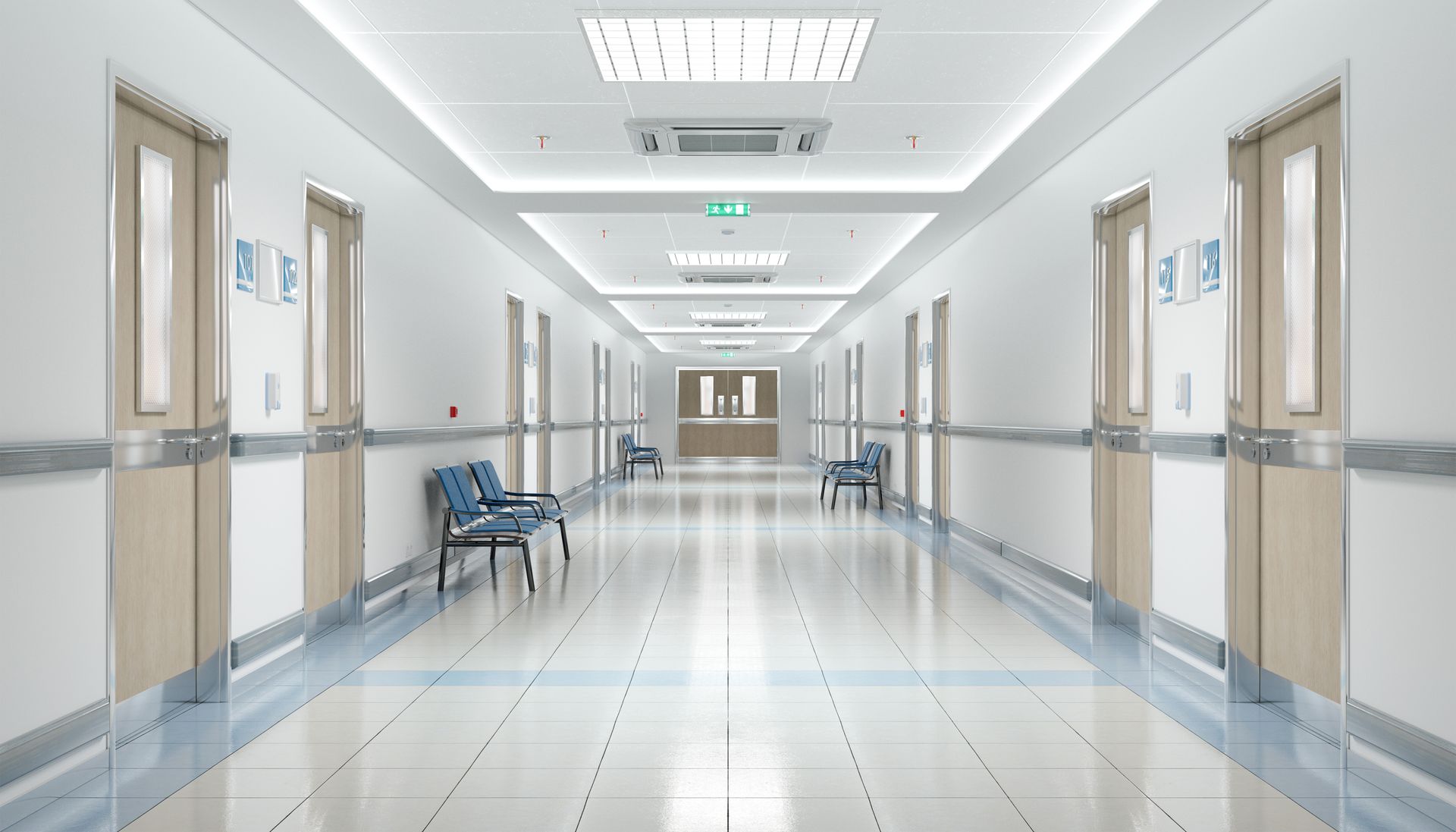 A bright, empty hospital hallway with white walls, tiled floors, wooden doors on both sides, and rows of blue chairs. A bright, empty hospital hallway with white walls, tiled floors, wooden doors on both sides, and rows of blue chairs.