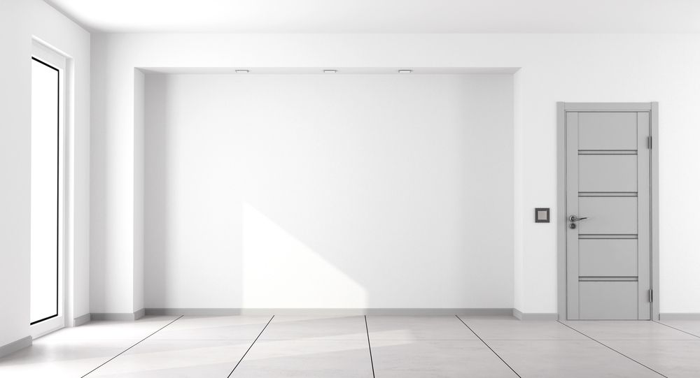 Minimalist room with white walls, light tile flooring, a recessed wall section, and a gray paneled door.