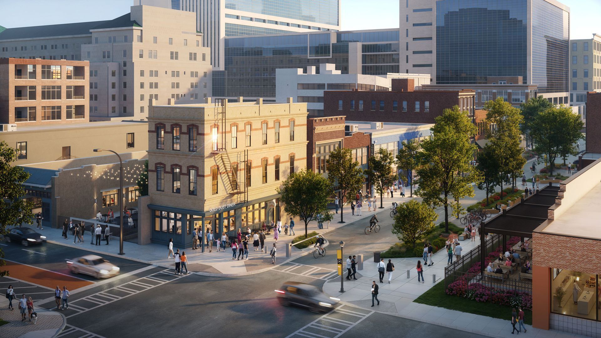 Downtown city street with pedestrians, trees, and brick buildings beside modern glass towers at sunset