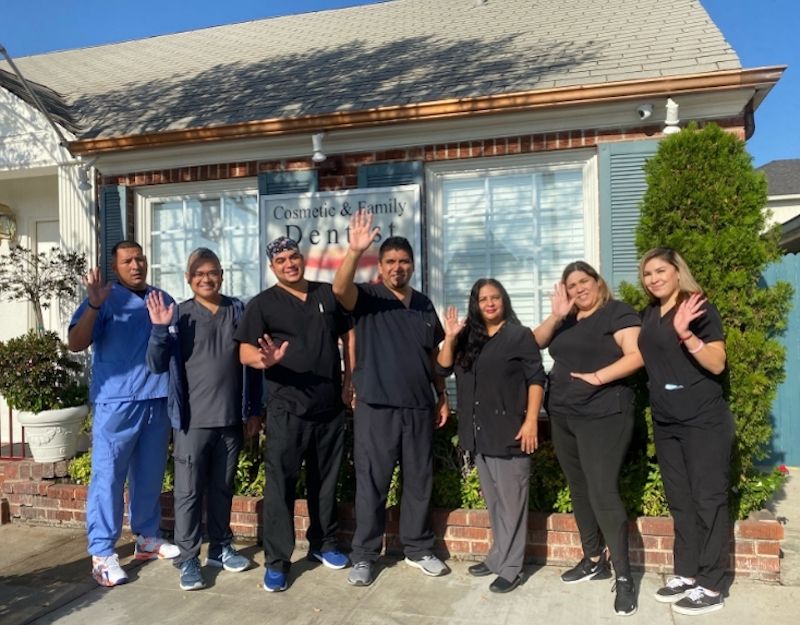 A group of people standing in front of a dental office