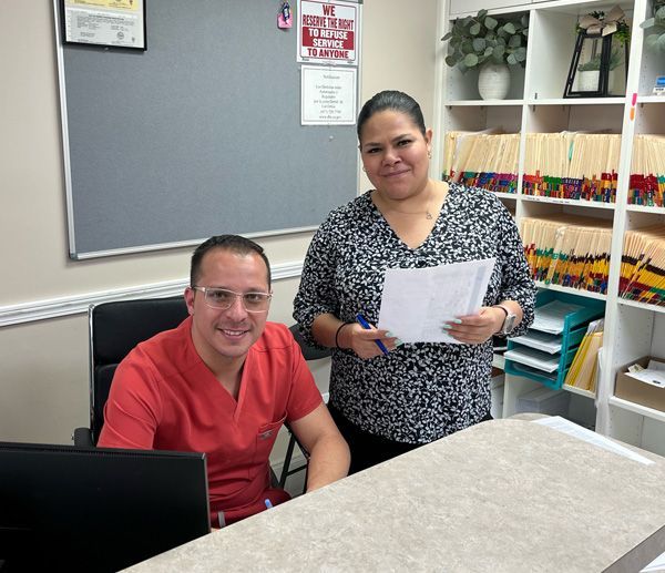 A man and a woman are standing next to each other at a desk