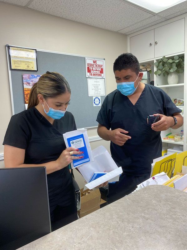 A man and a woman wearing masks are standing next to each other in a room.