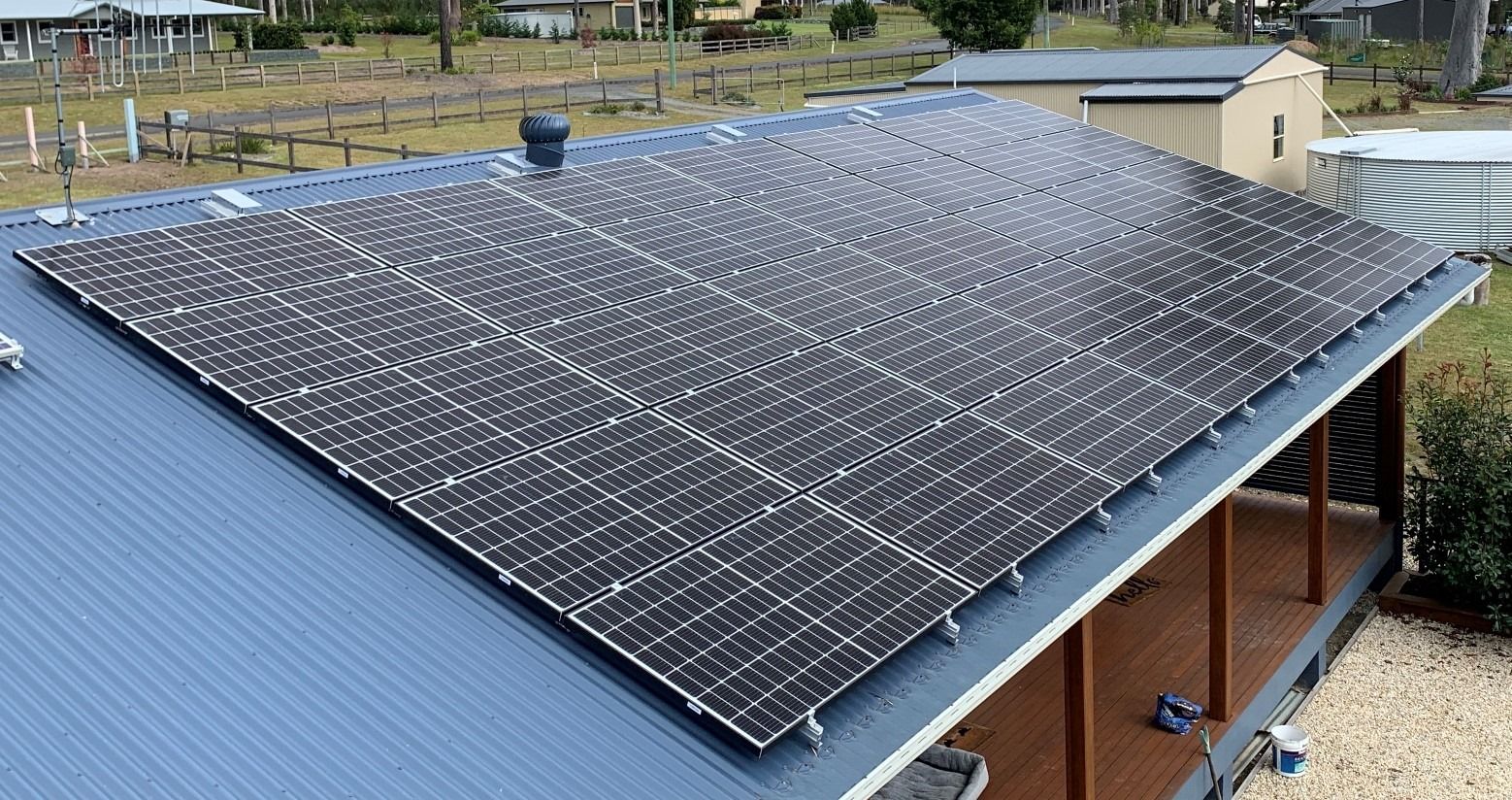Two Men Are Installing Solar Panels On The Roof Of A House — Forster Solar and Lighting In Forster, NSW