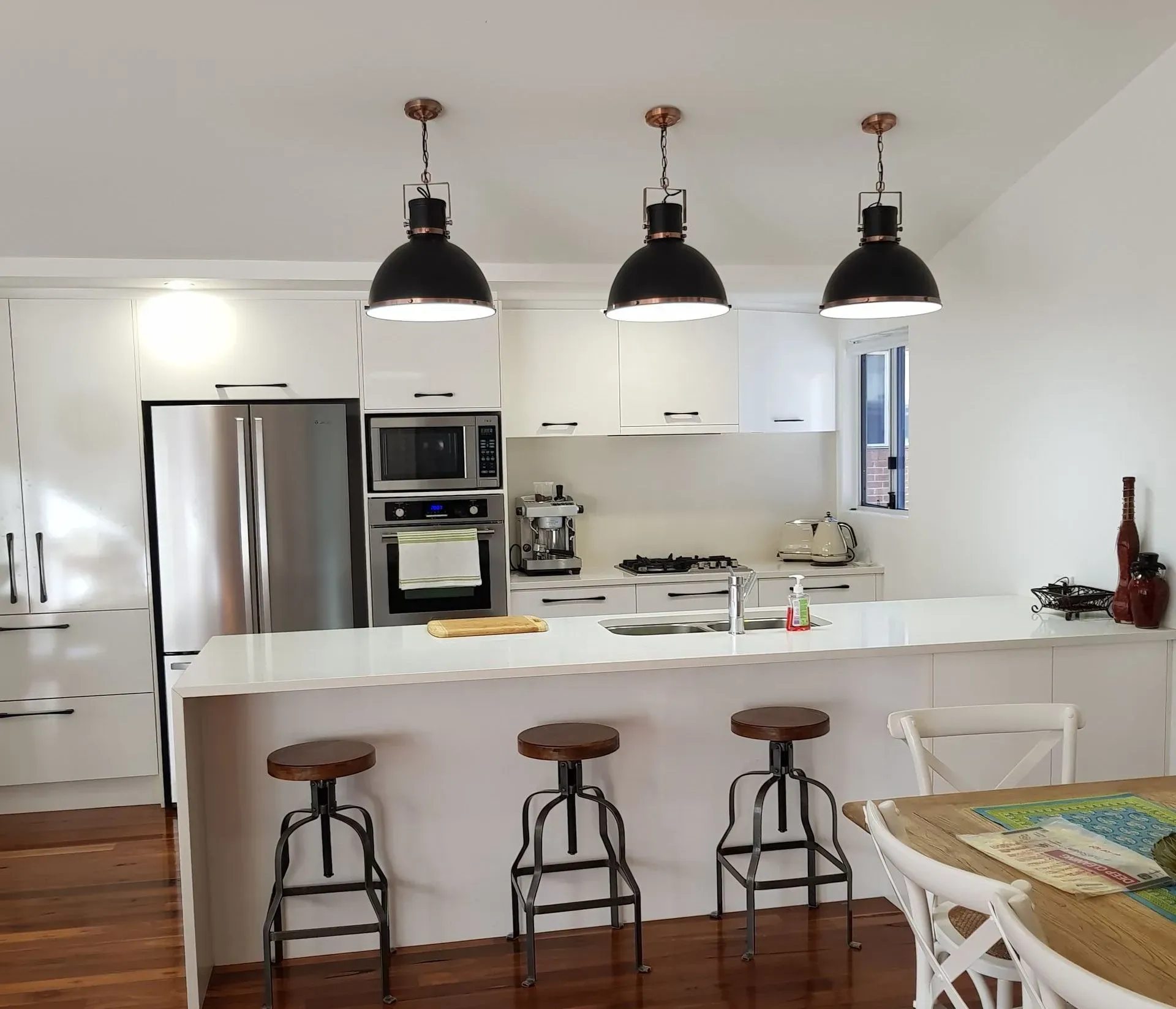 A Row Of Clear Glass Pendant Lights Hanging From The Ceiling In A Restaurant — Forster Solar and Lighting In Forster, NSW