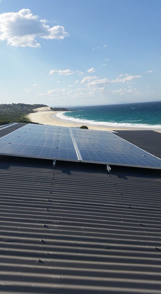 A White House With A Balcony And Solar Panels On The Roof — Forster Solar and Lighting In Forster, NSW