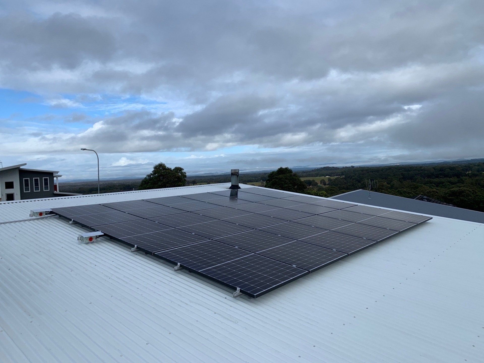 Three Men Are Installing Solar Panels On A Roof — Forster Solar and Lighting In Forster, NSW