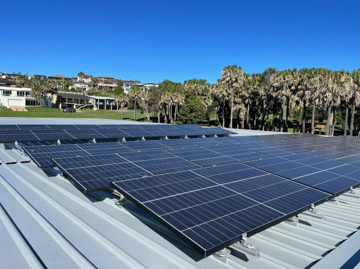 Two Men Are Installing Solar Panels On The Roof Of A House — Forster Solar and Lighting In Forster, NSW