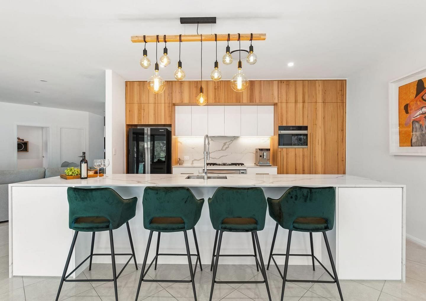 A Kitchen With A Large Island And Four Bar Stools — Forster Solar and Lighting In Forster, NSW