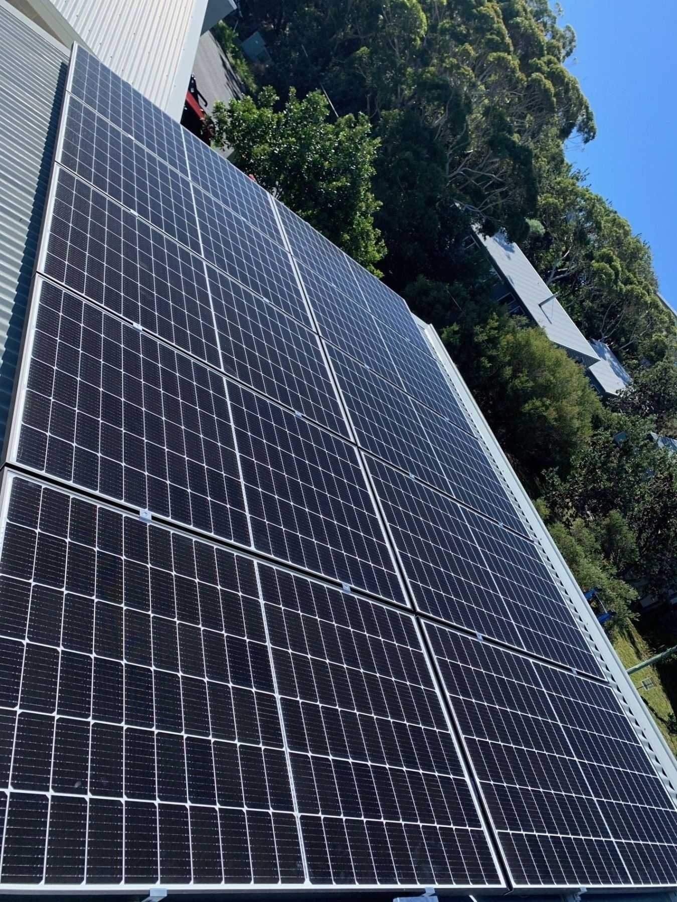 A Row Of Solar Panels Against A Blue Sky With Clouds — Forster Solar and Lighting In Tuncurry, NSW