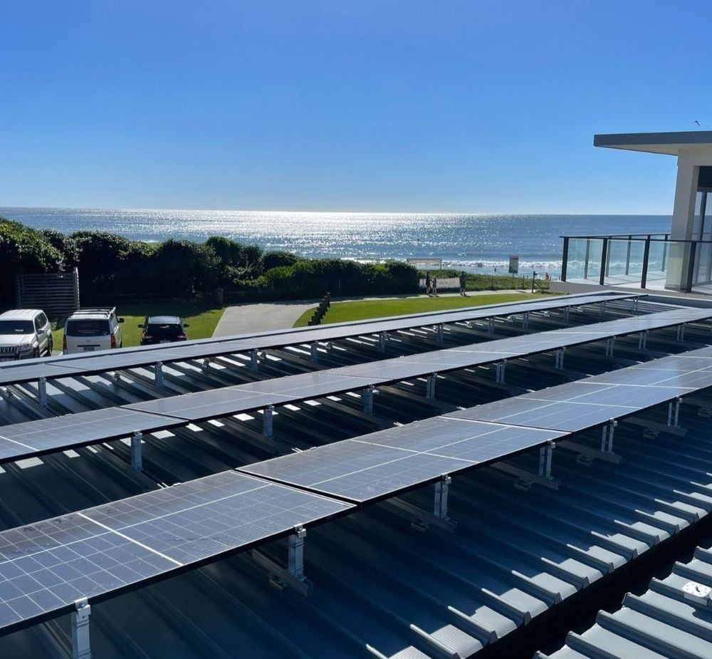 Two Men Are Installing Solar Panels On The Roof Of A Building — Forster Solar and Lighting In Forster, NSW