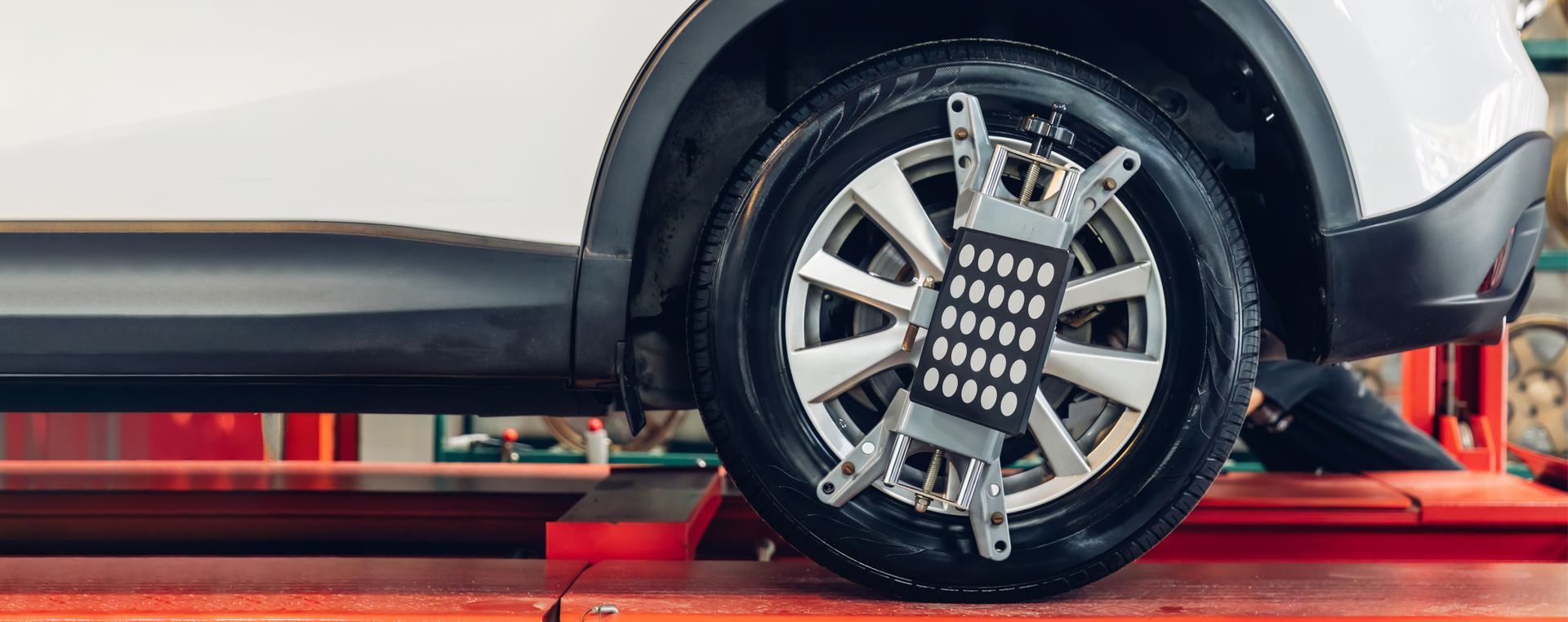 Car on a wheel alignment lift in an auto garage