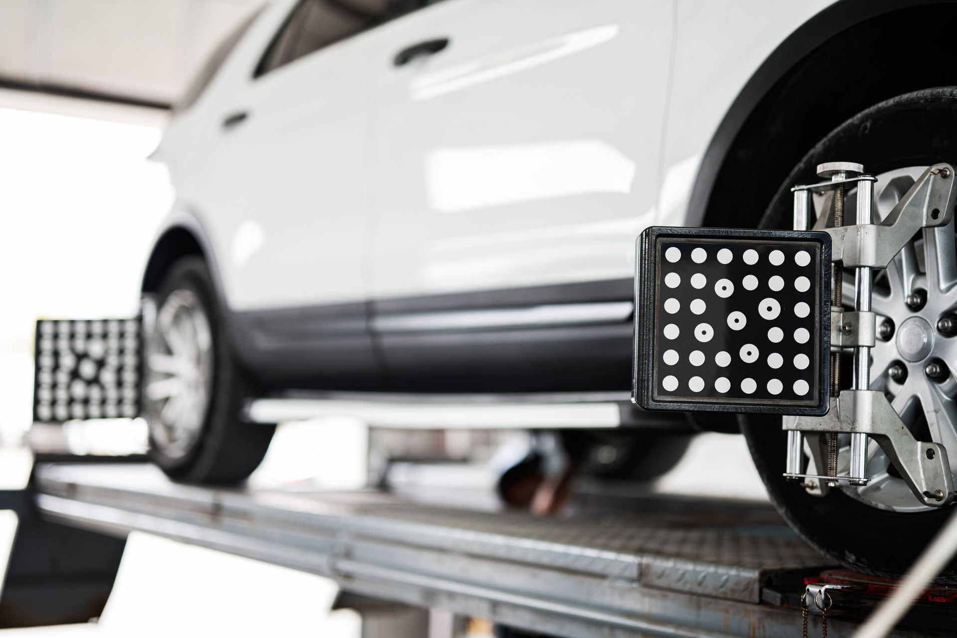 Mechanic performing a four wheel alignment on a car