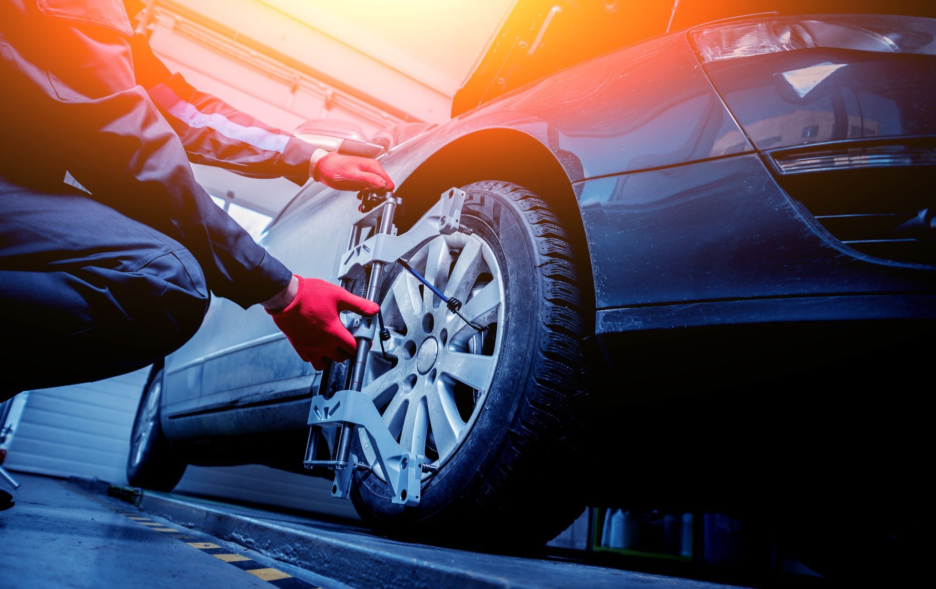 Mechanic inspecting a red car with a diagnostic screen in an auto service bay
