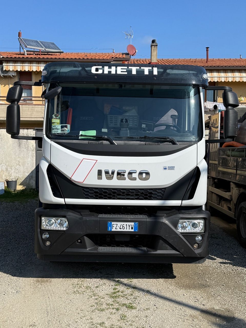 Persona che utilizza uno strumento per ispezionare un tombino fognario su un patio in mattoni.