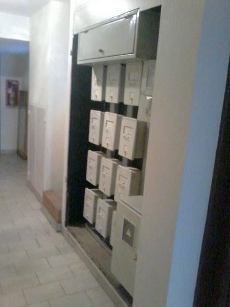 Pasillo con una hilera de buzones blancos y armarios montados en la pared