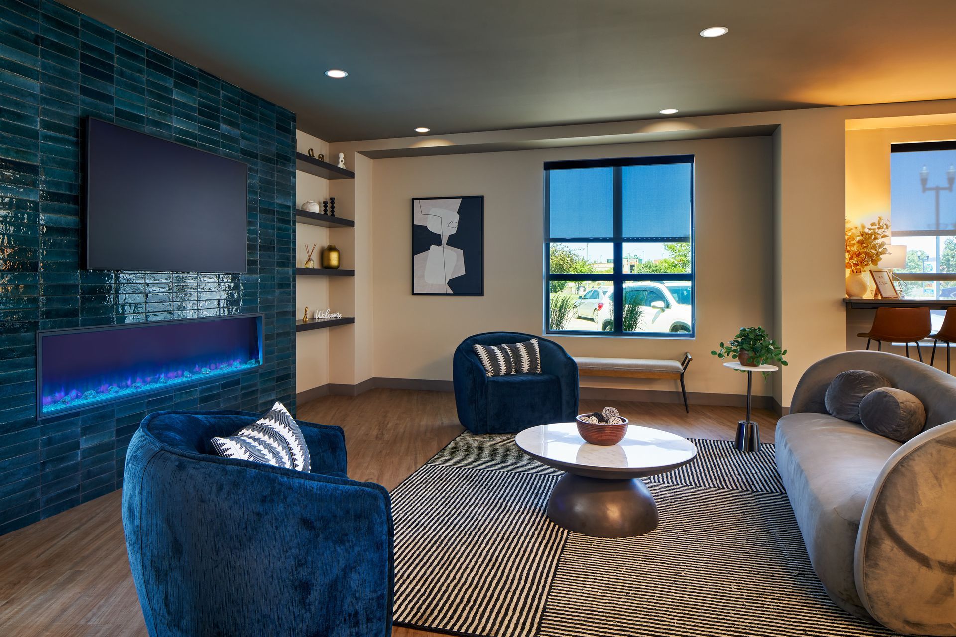 Living room with blue accents, including a tiled wall, chairs, and a rug.