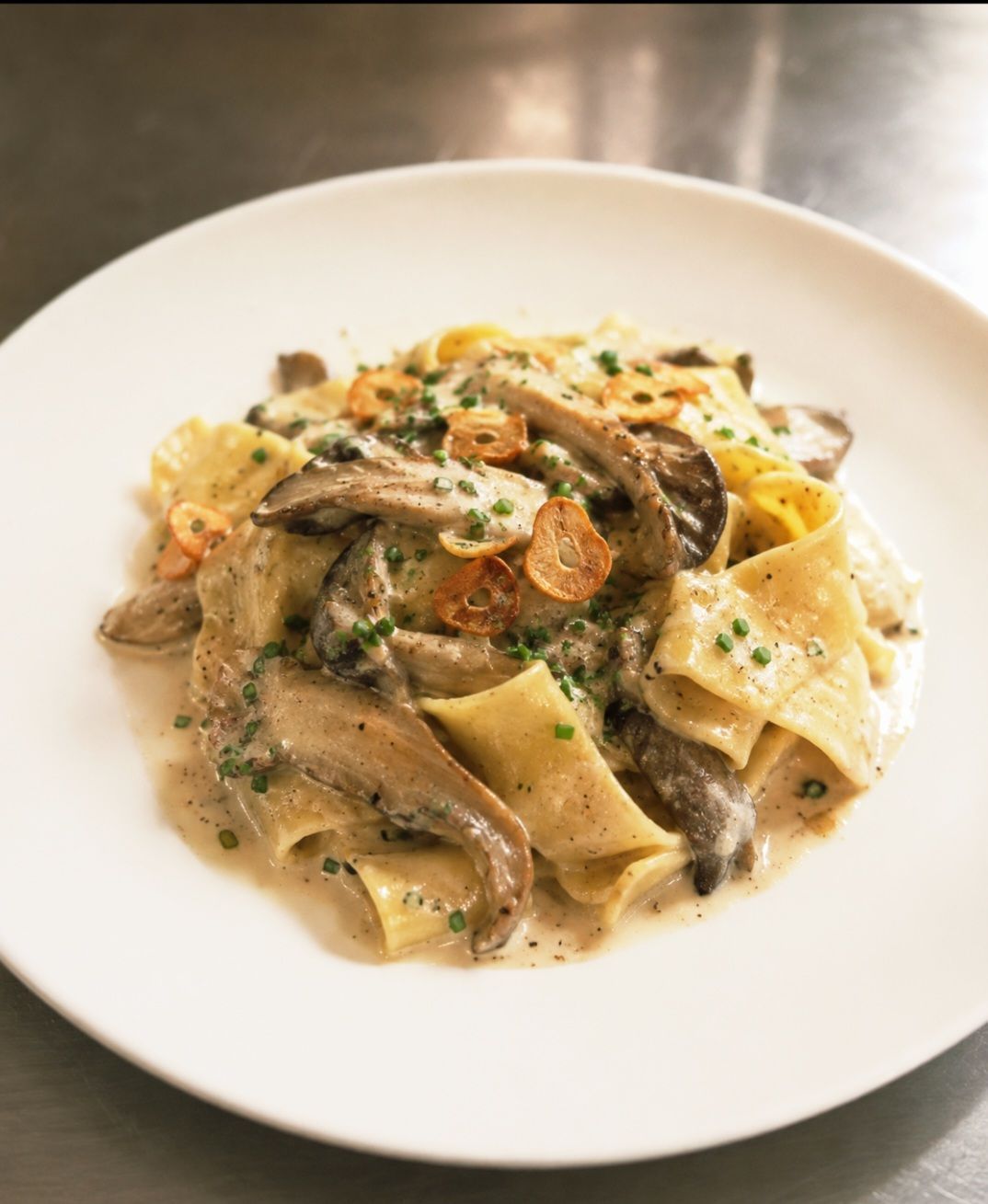 Creamy pasta with mushrooms and herbs on a white plate
