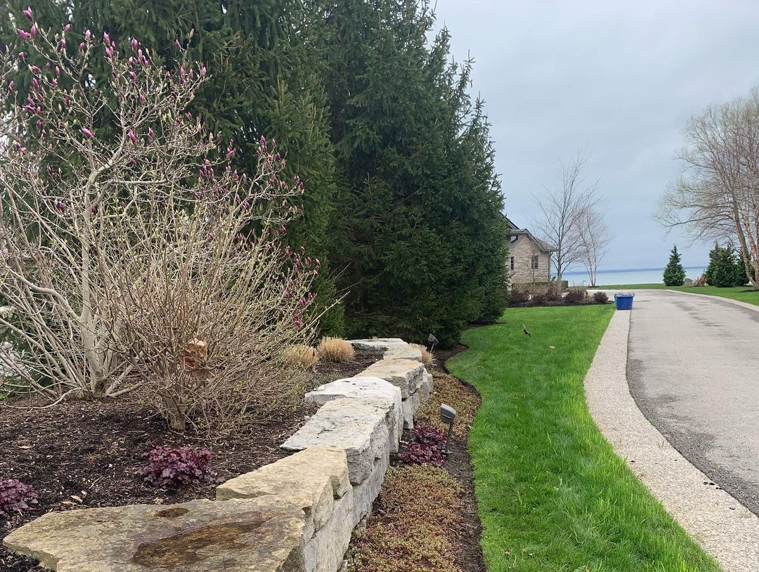There is a stone wall along the side of the road.