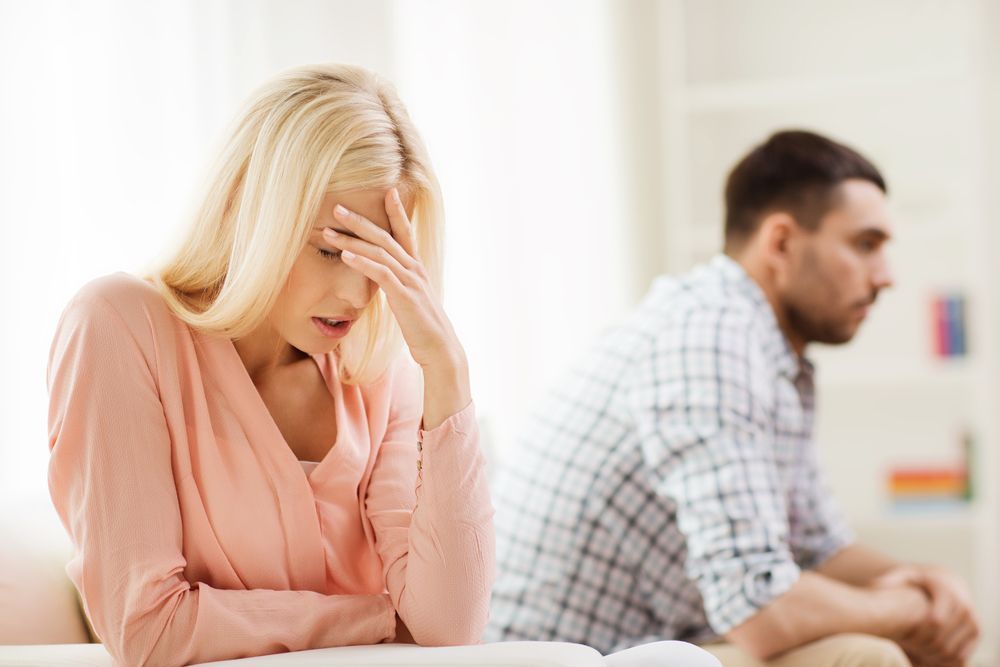A woman is sitting on a couch next to a man.