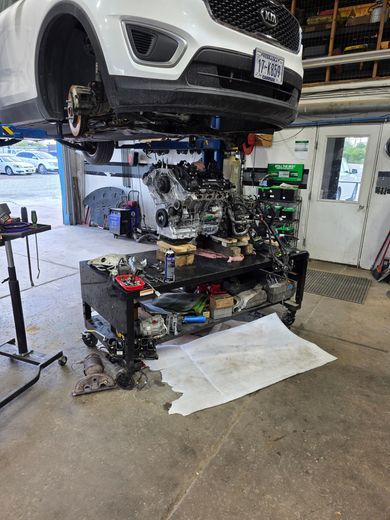 Kia SUV lifted on a garage hoist with its engine removed | The Car Clinic LLC