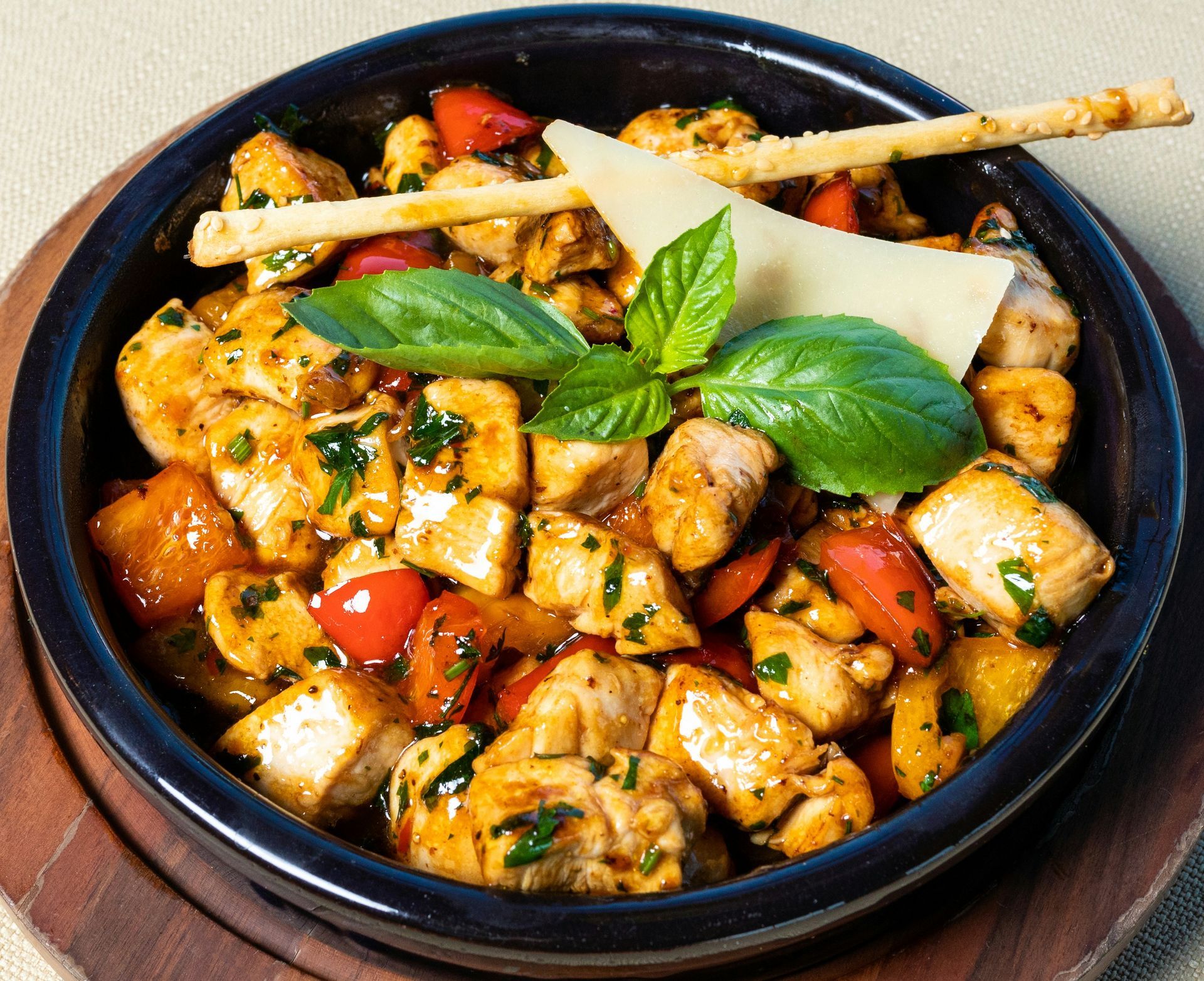 A bowl of food with chicken tomatoes basil and cheese
