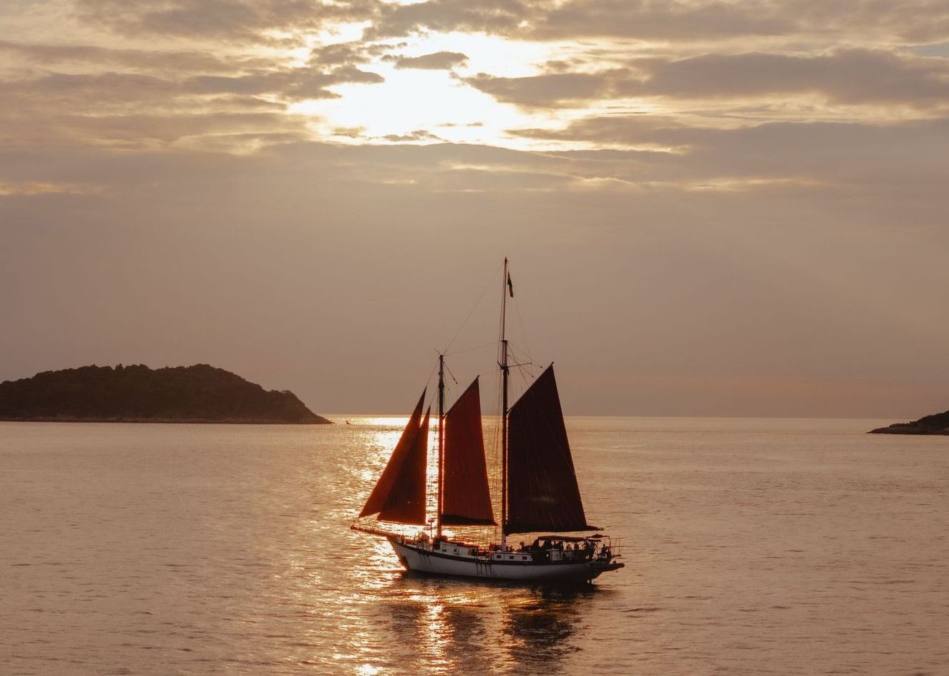 A sailboat on water at sunset.
