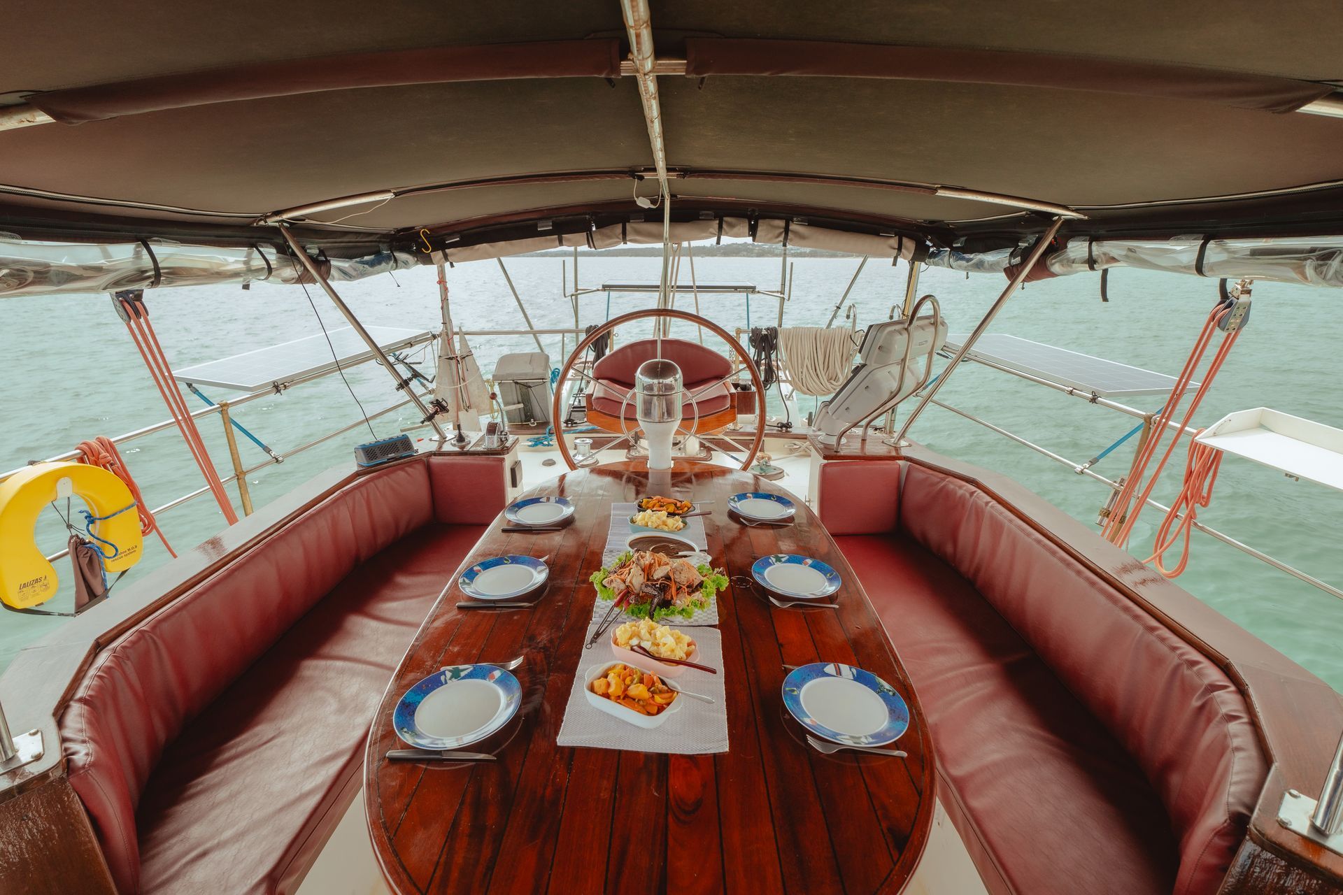 A boat with a long wooden table and plates on it.