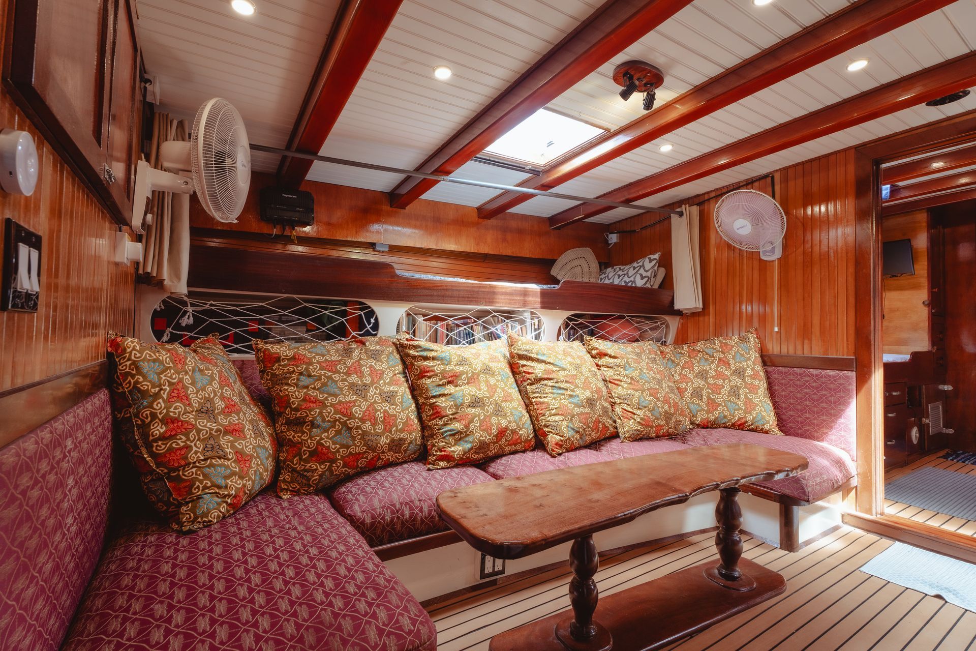 A living room on a boat with a couch and a table.