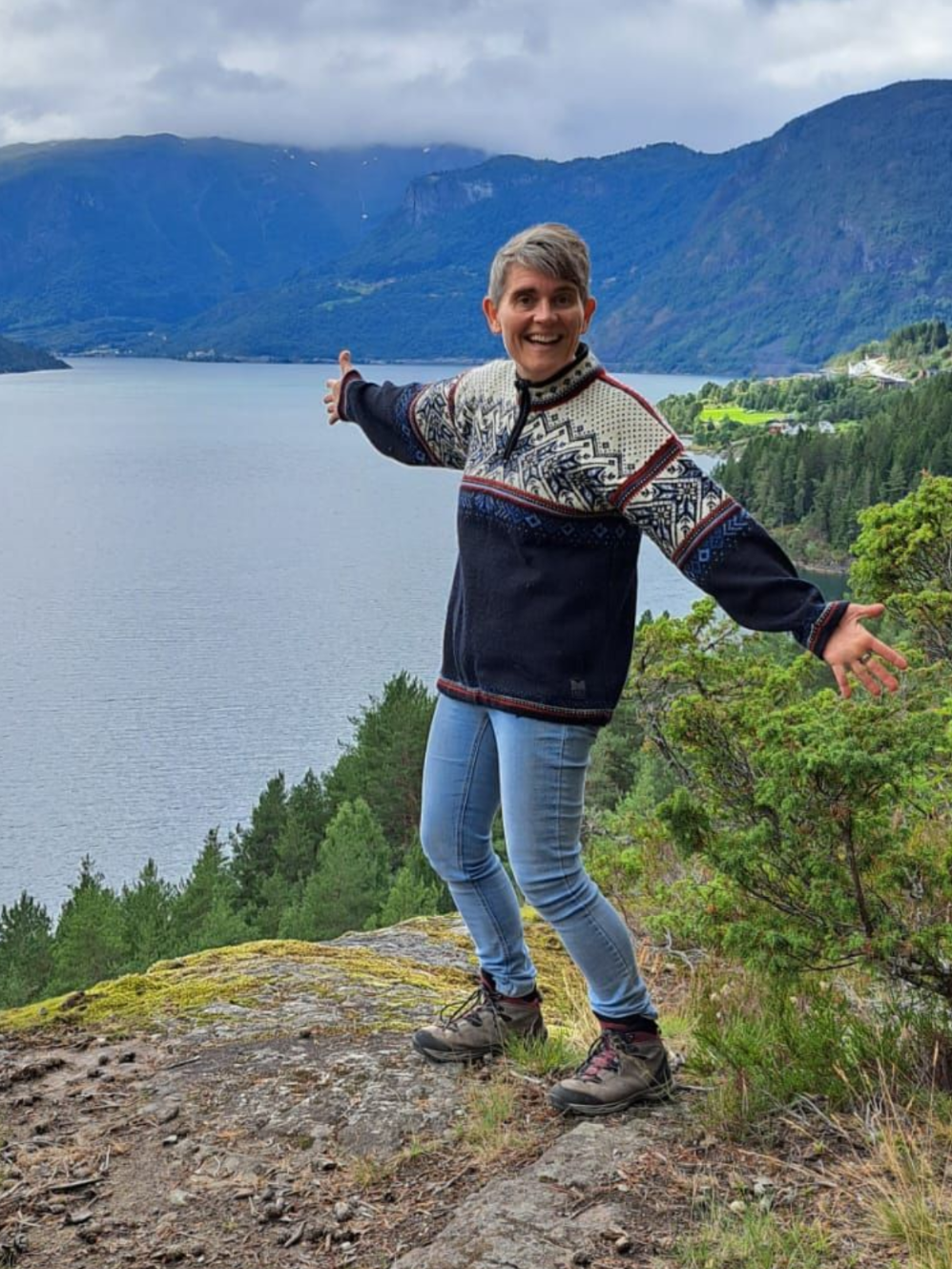 Monica van Happy Healthy Live met armen open op de berg met uitzicht op het fjord als symbool voor vrijheid en groei