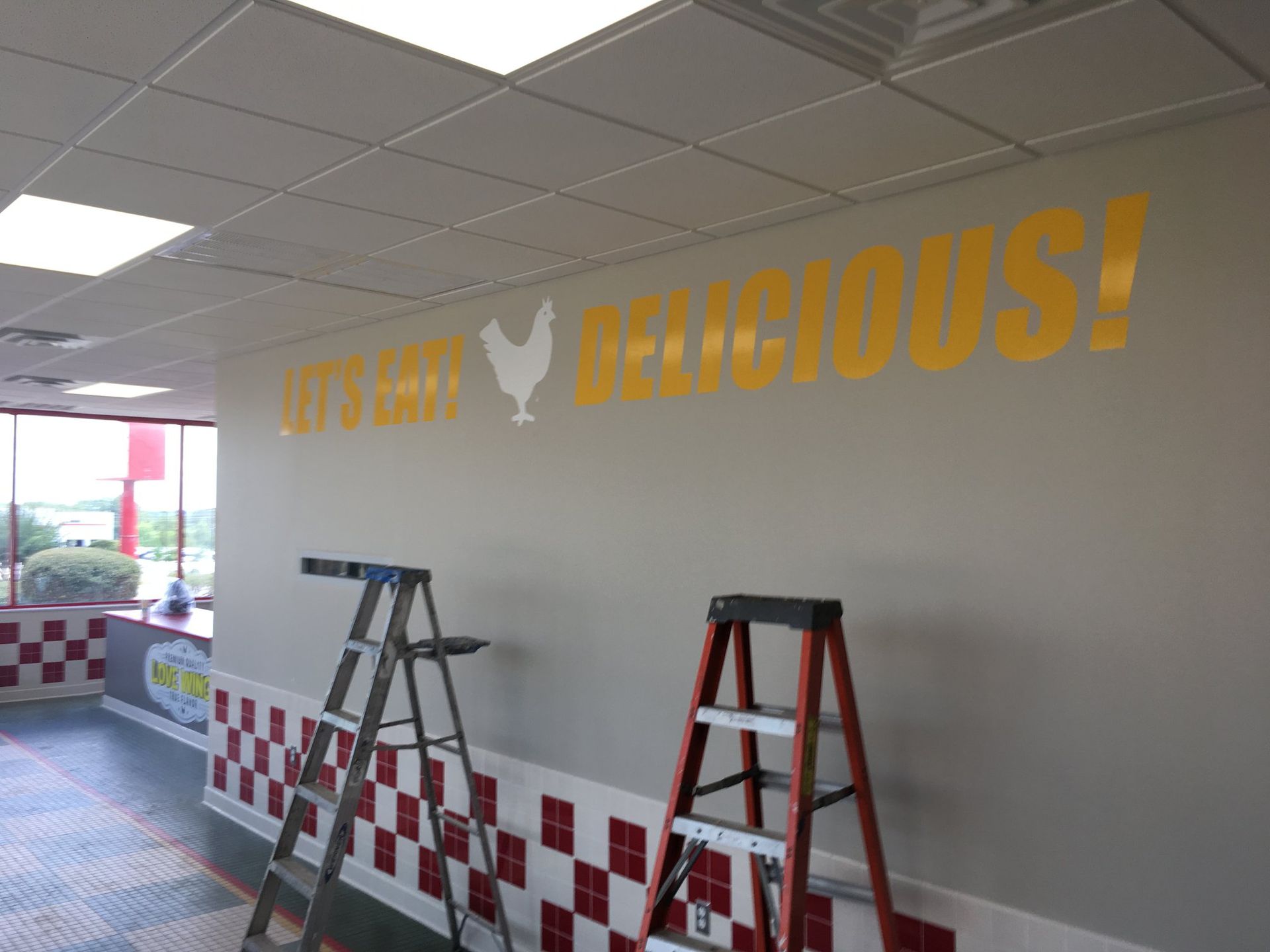 Interior of a restaurant with a wall featuring the yellow text 