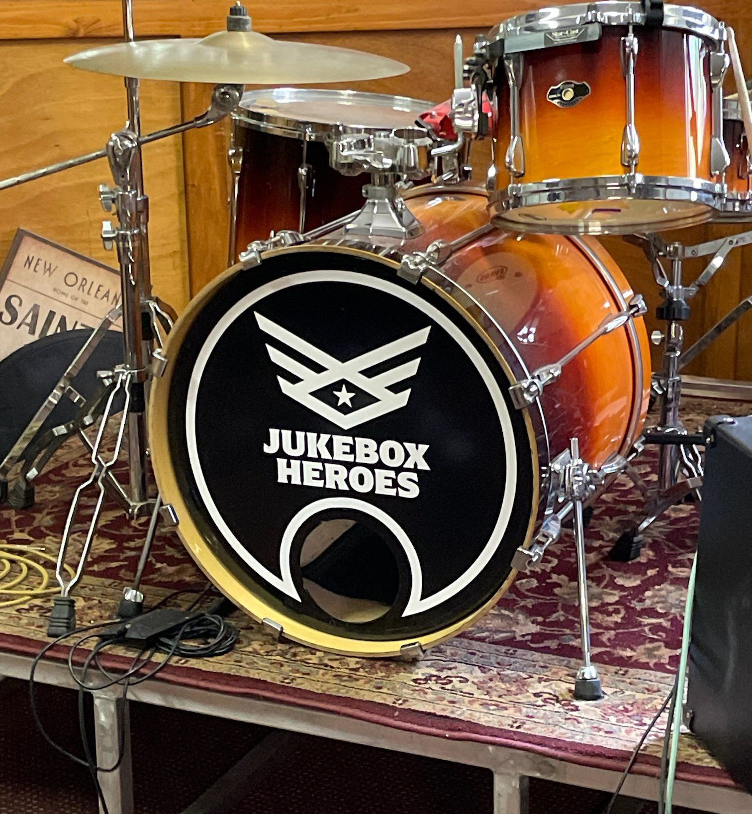 A drum kit on a stage, featuring a bass drum with a 