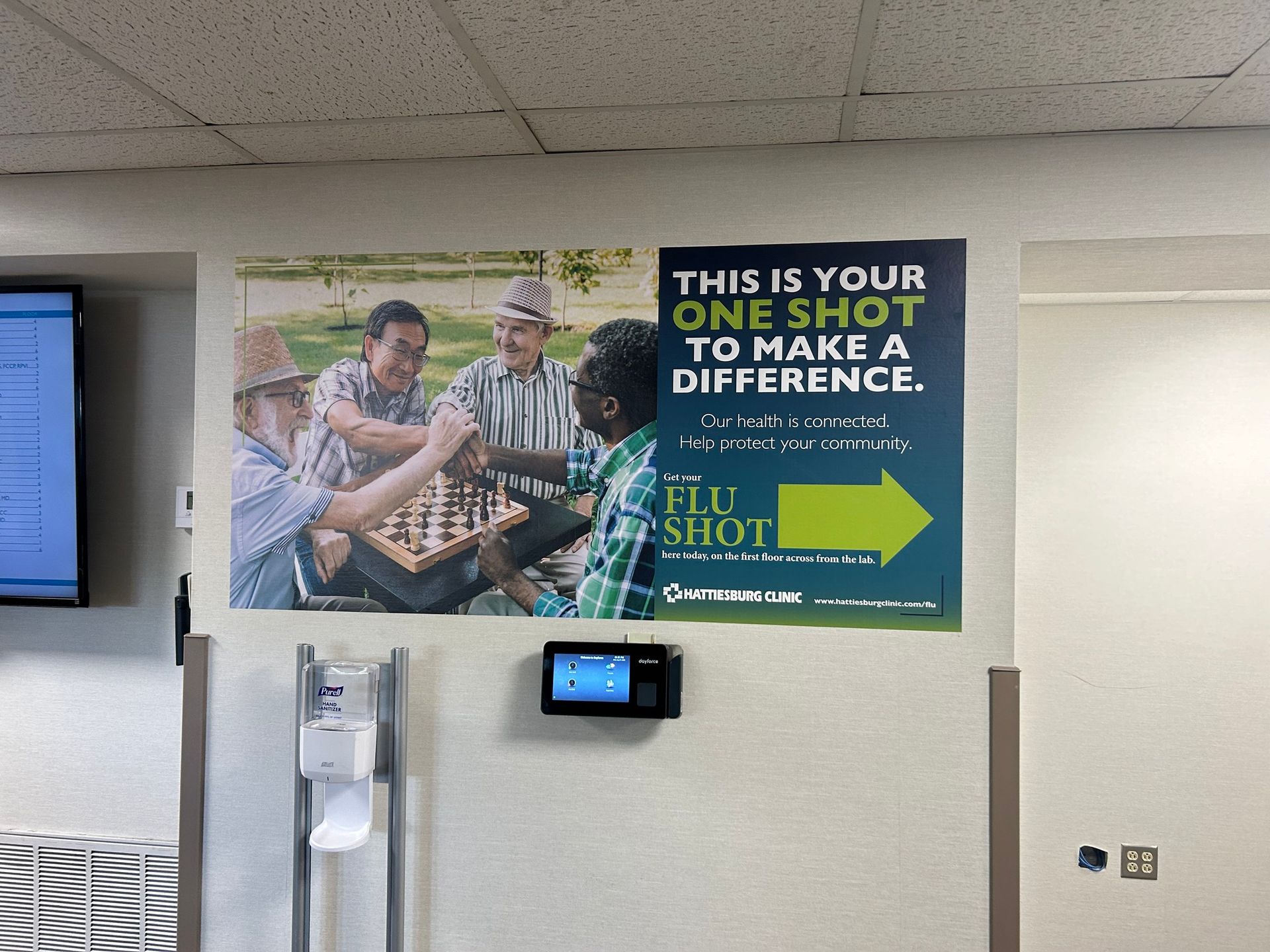 A poster on a wall showing four people playing chess, with text encouraging people to get a flu shot.