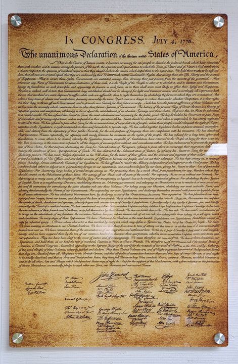 A framed copy of the United States Declaration of Independence on parchment-colored paper, mounted on a wall.