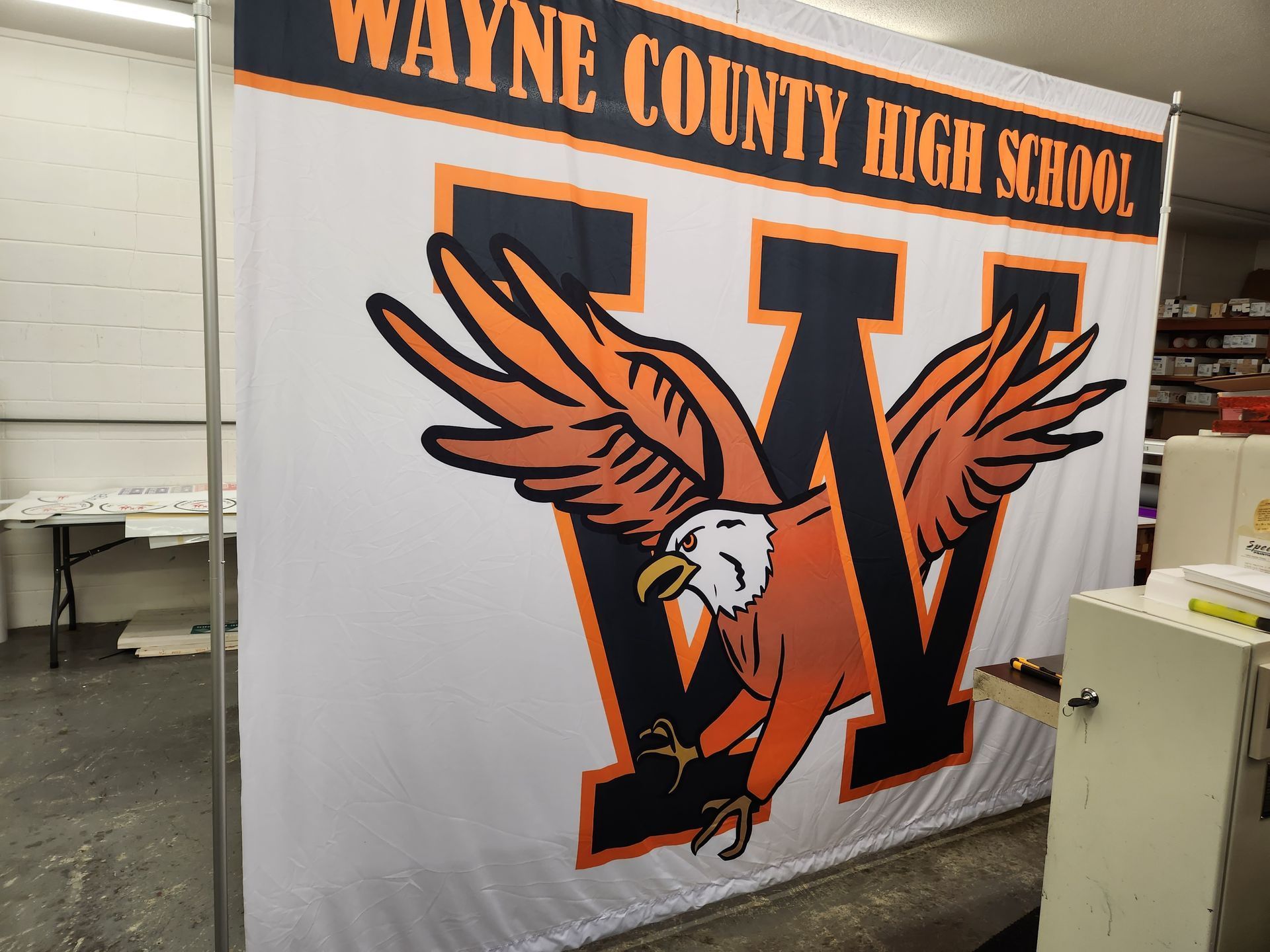 A large white banner for Wayne County High School featuring a large navy blue 