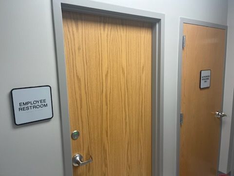 Two doors with wood grain texture in a hallway, one labeled 