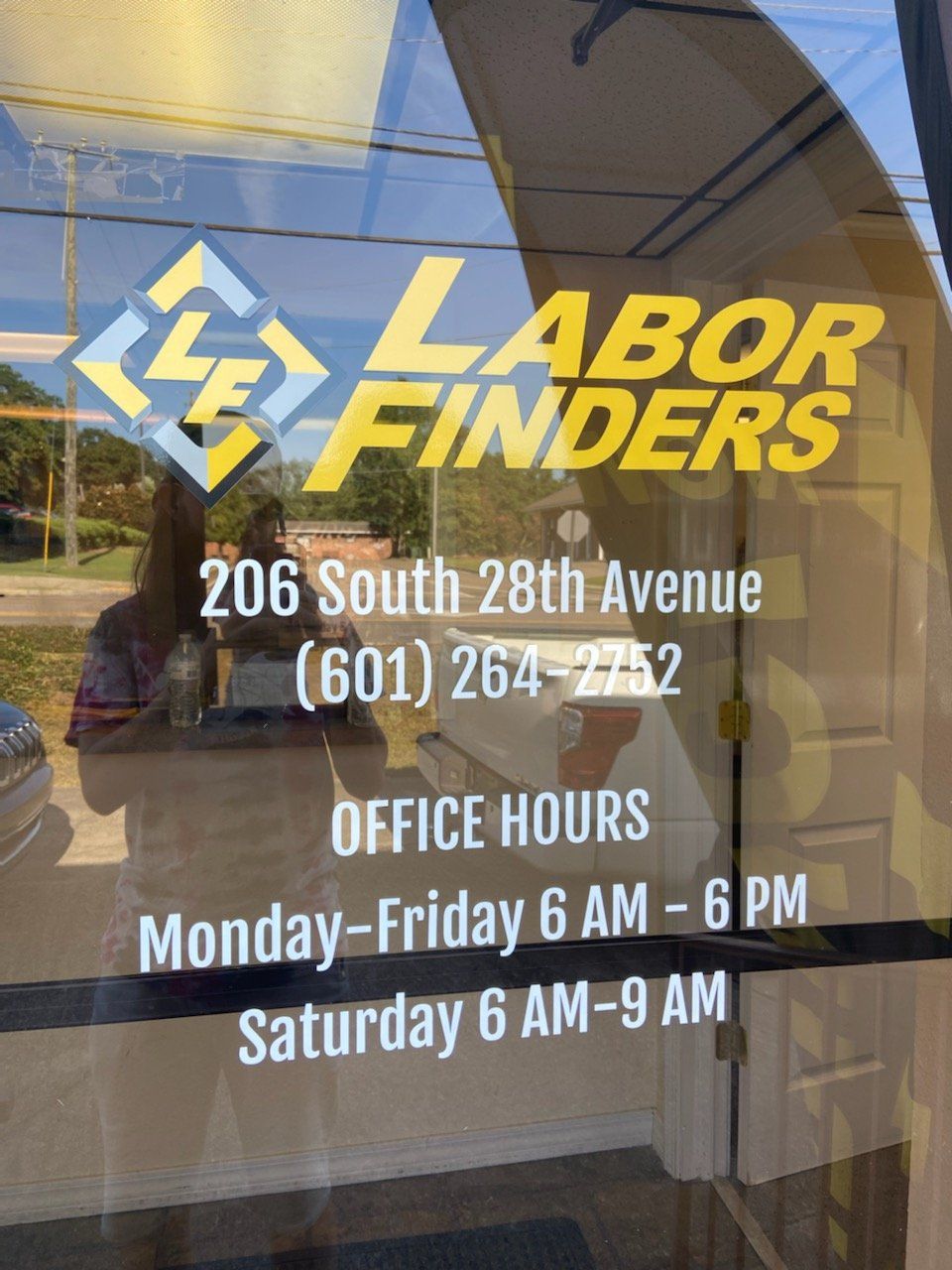 Glass door displaying Labor Finders company logo, address 206 South 28th Avenue, phone number, and operating hours.