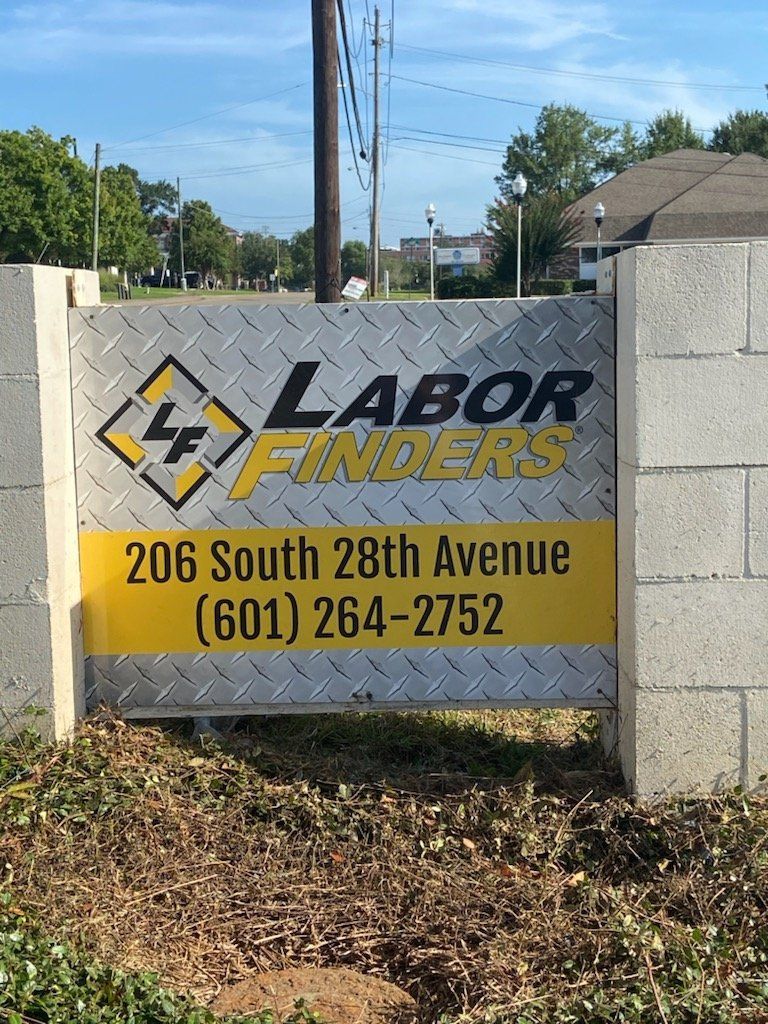 A sign for Labor Finders, located at 206 South 28th Avenue, with the phone number (601) 264-2752, set in a stone base.