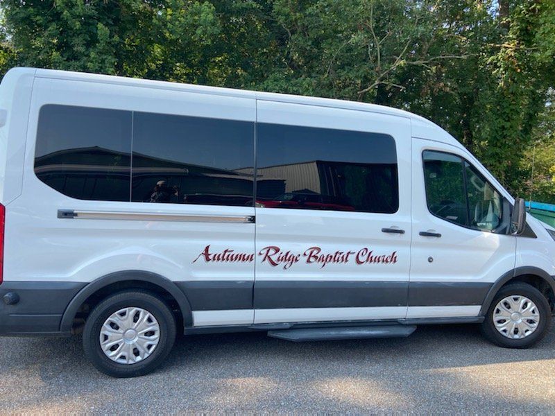 White Ford Transit passenger van with 