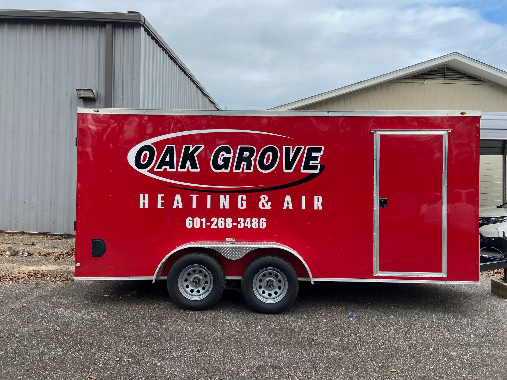 A bright red utility trailer parked outdoors, branded with the text 
