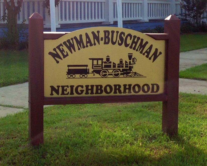 A yellow sign on a red wooden frame reads