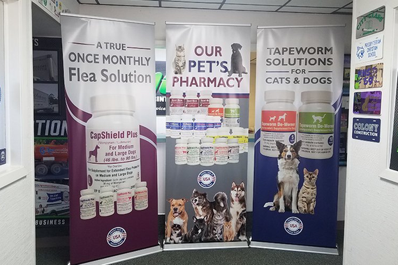 Three pull-up banners for a pet pharmacy advertising flea and tapeworm treatments for cats and dogs.