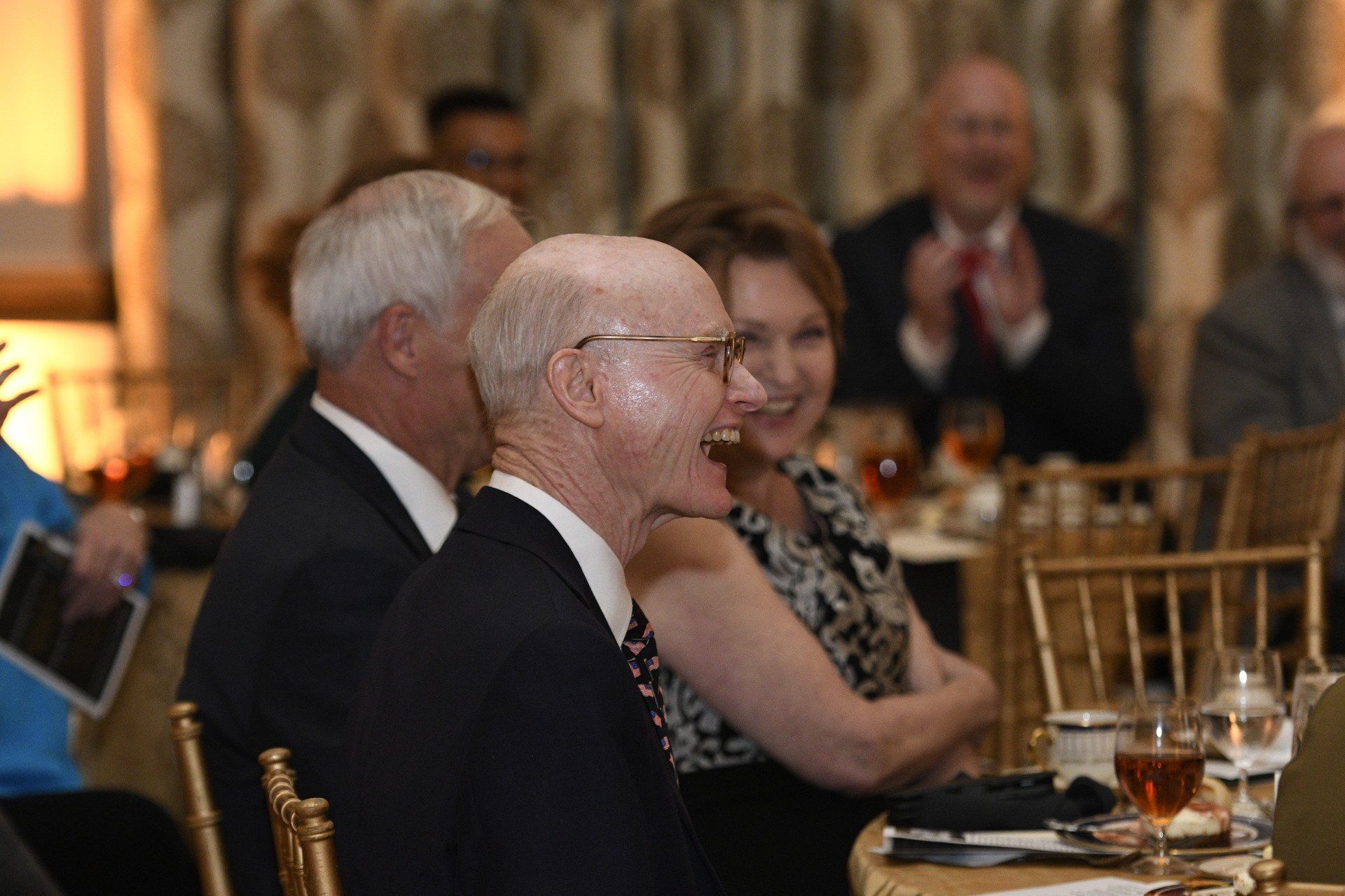A group of people are sitting at a table with glasses of wine.