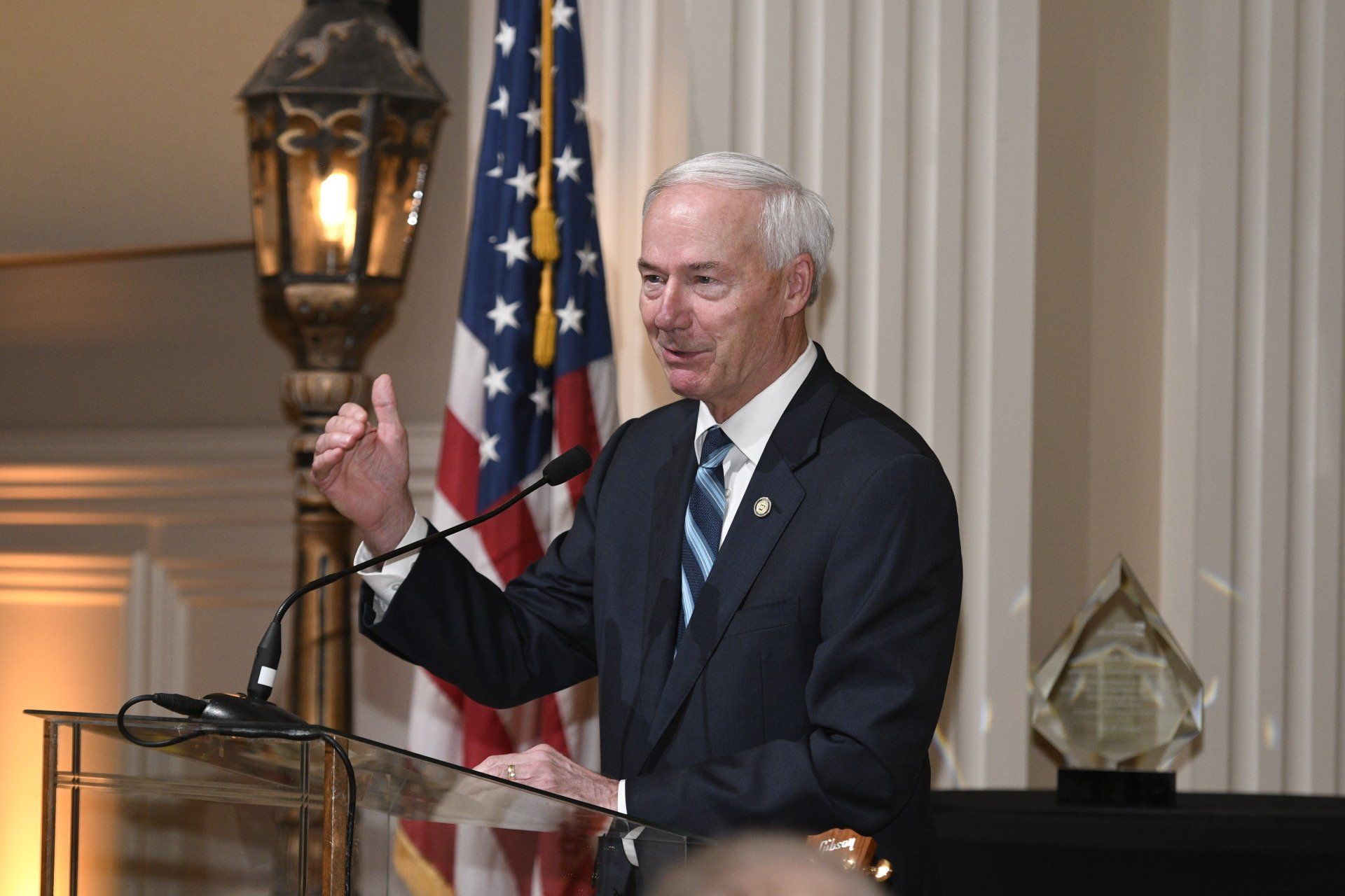 A man in a suit and tie is standing at a podium giving a speech.