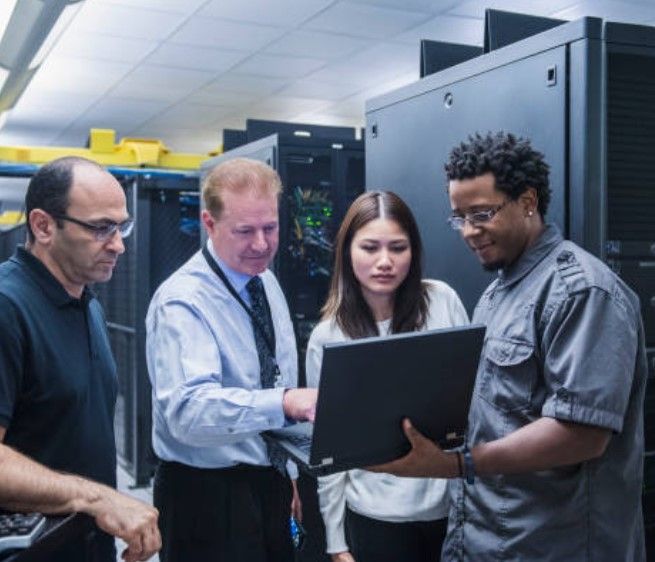 A man and a woman are looking at a tablet in a server room. A man and a woman are looking at a tablet in a server room.