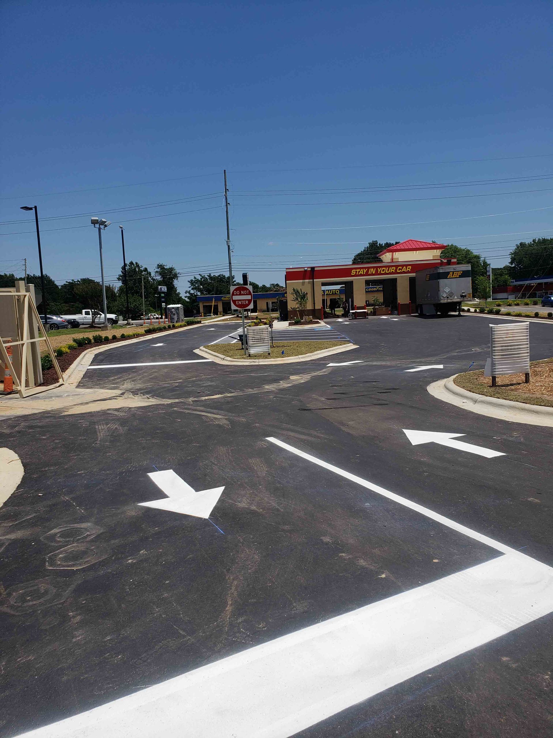 A parking lot with white arrows pointing in opposite directions
