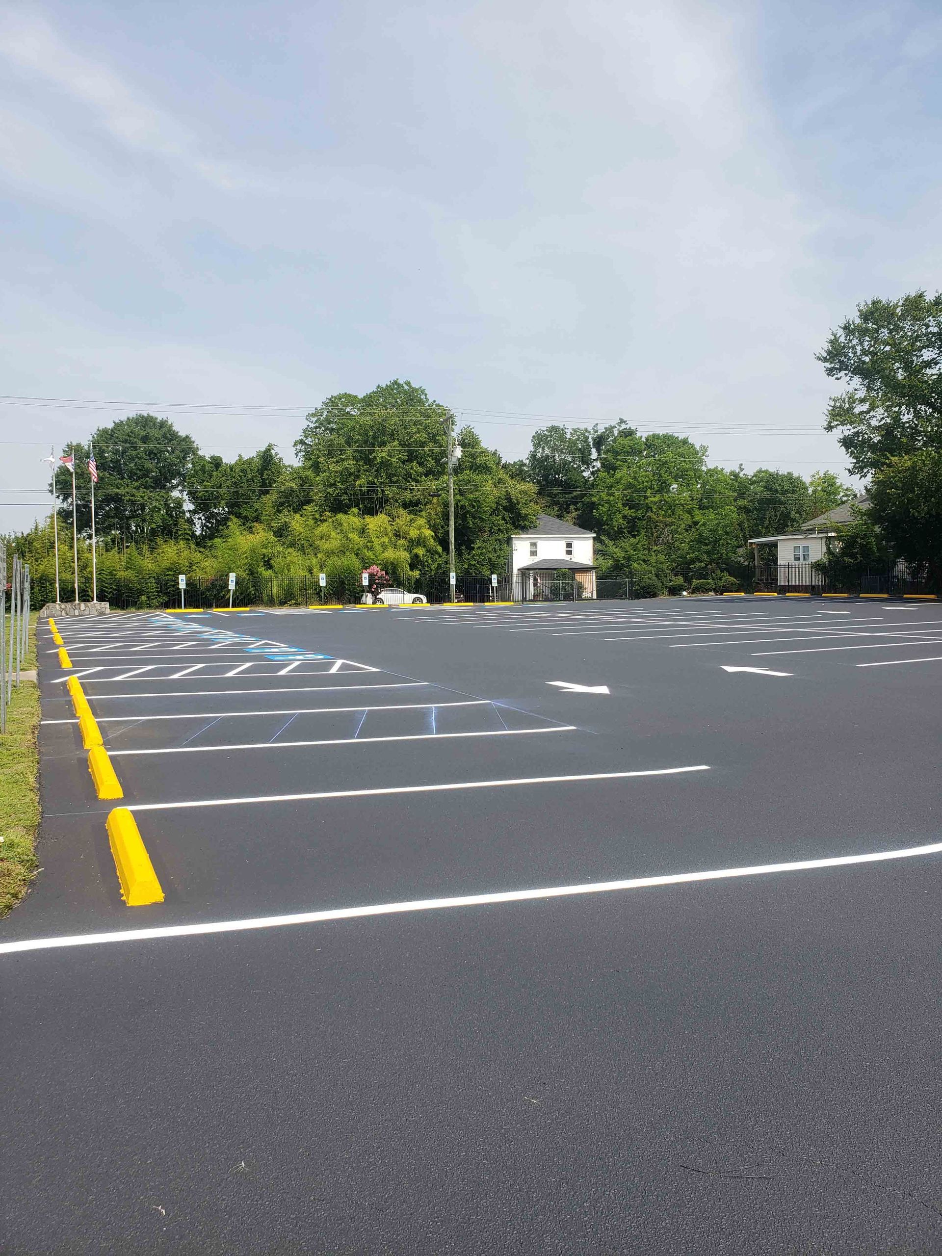 An empty parking lot with trees in the background