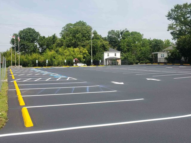A large parking lot with a house in the background